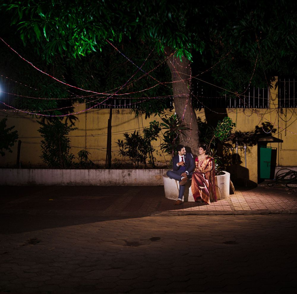 A nighttime wedding portrait with fairy lights and trees creating an intimate atmosphere.