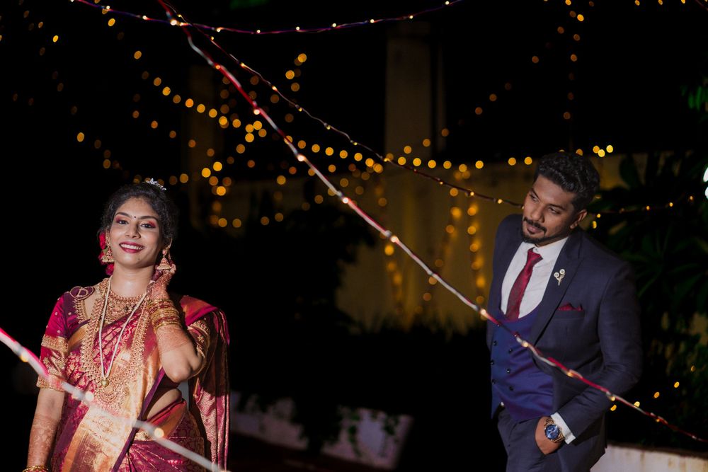 A festive evening wedding photograph with decorative string lights creating a magical ambiance.