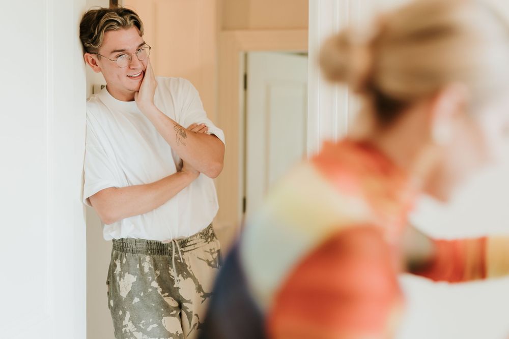 A candid interior shot capturing interactions between two figures in a hallway.