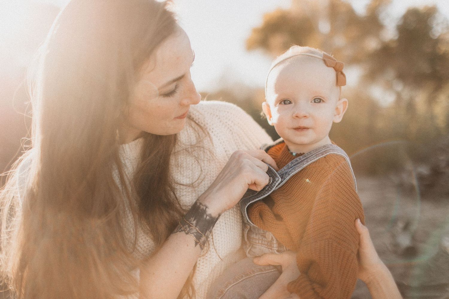 Sun-drenched family portrait with children against golden grass background.
