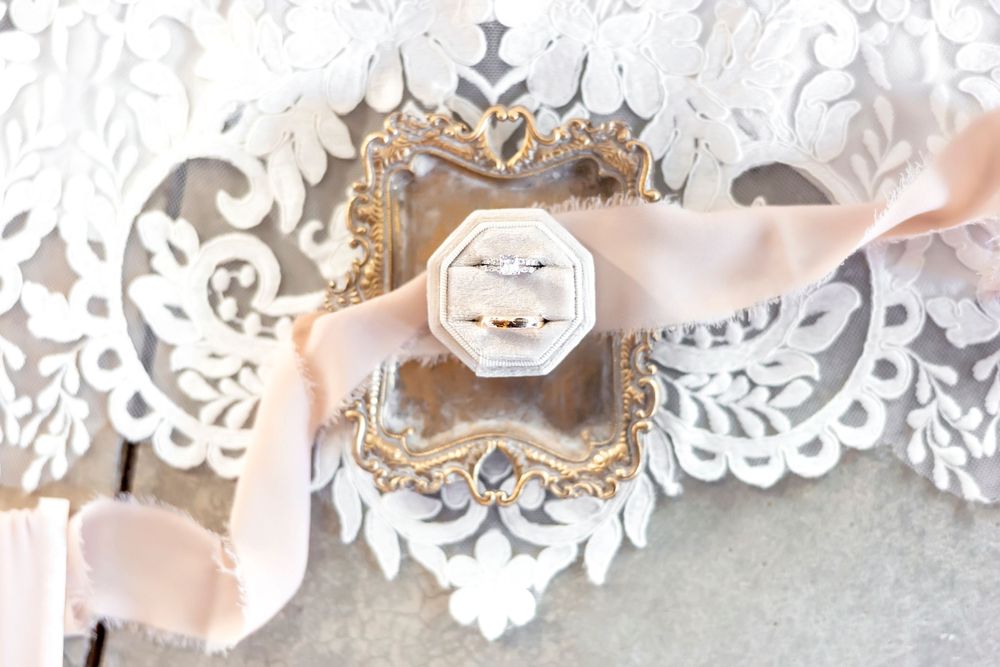 Delicate white lace and floral decorative elements with soft pink ribbon accents.