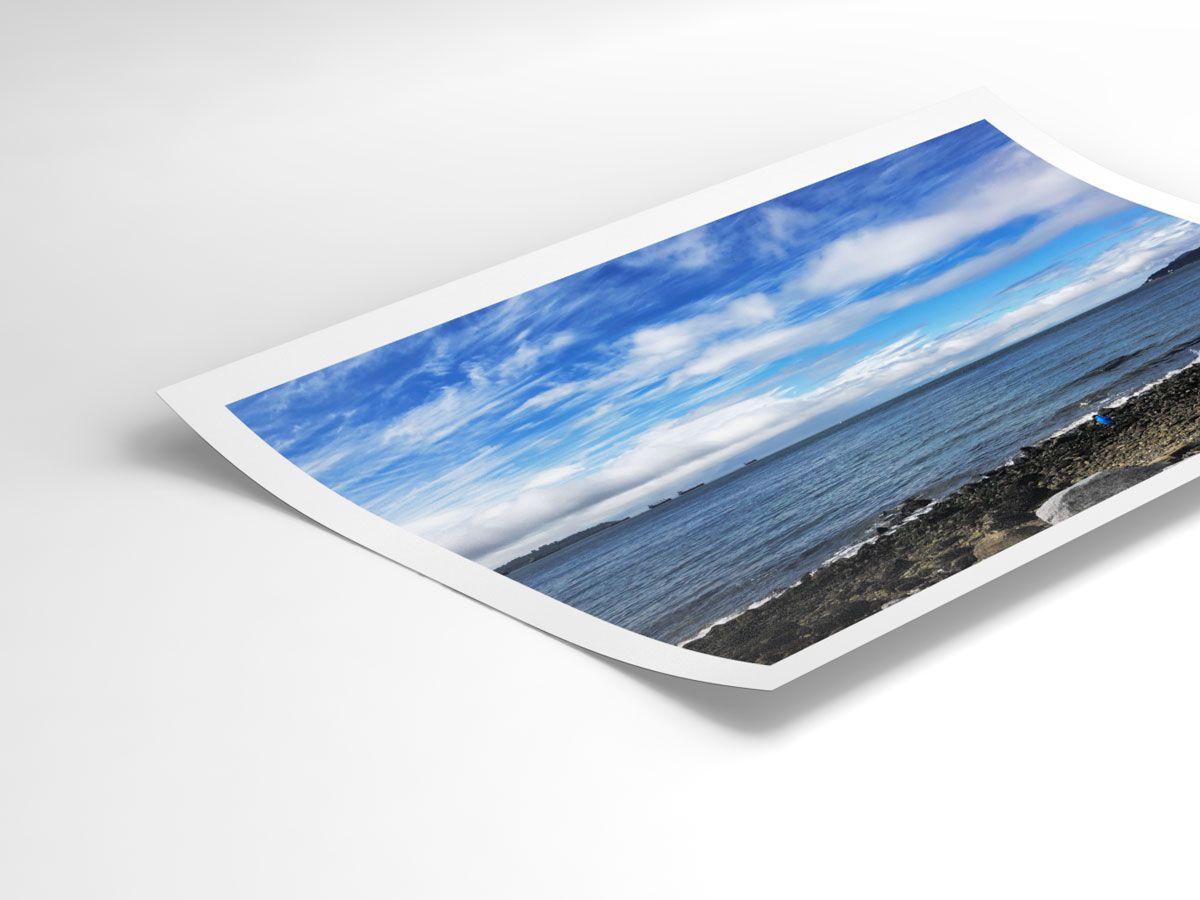 A crisp coastal horizon captured in print—calm waves under an endless blue sky.