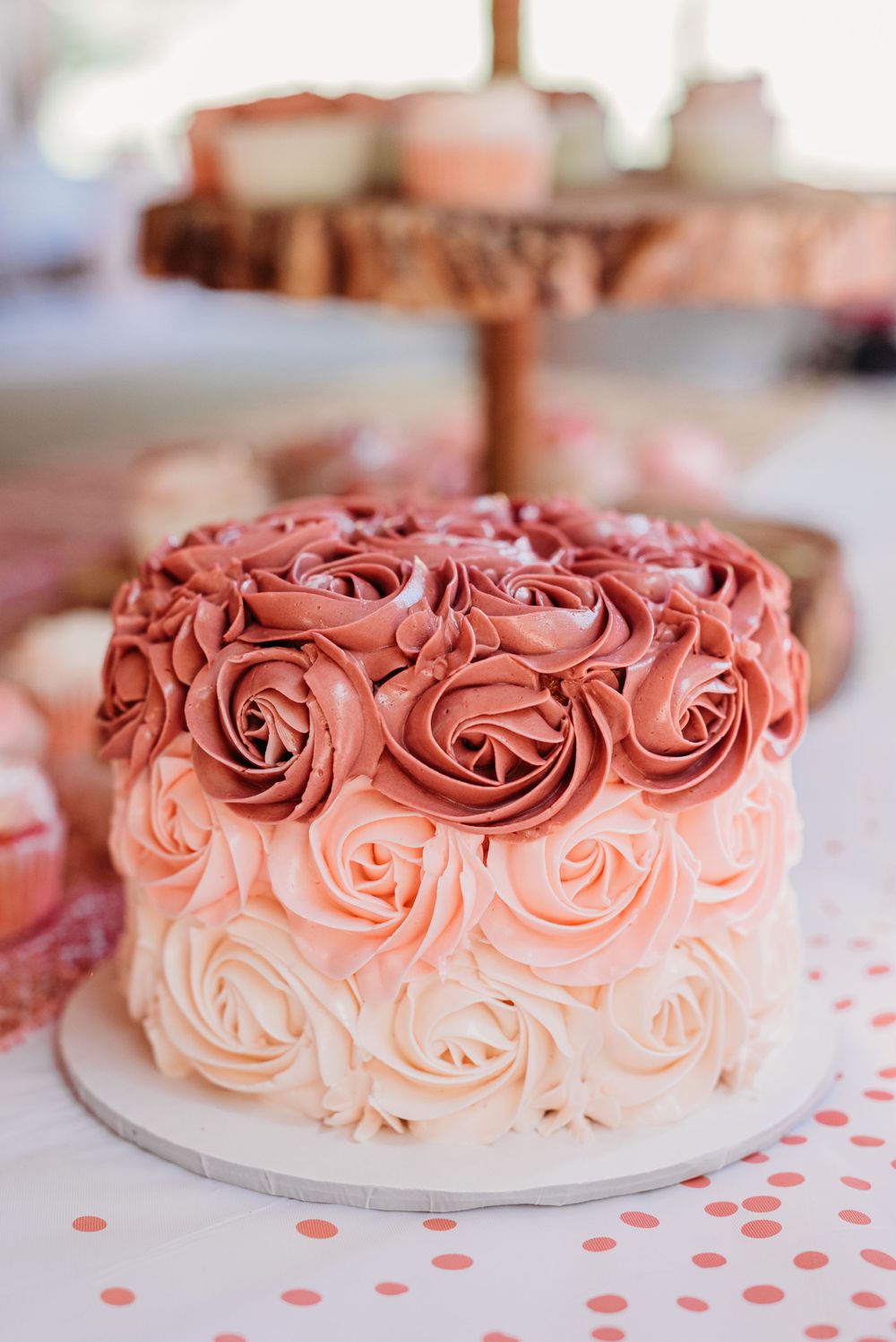 Ombre rose cake decorated in coral and pink frosting swirls.