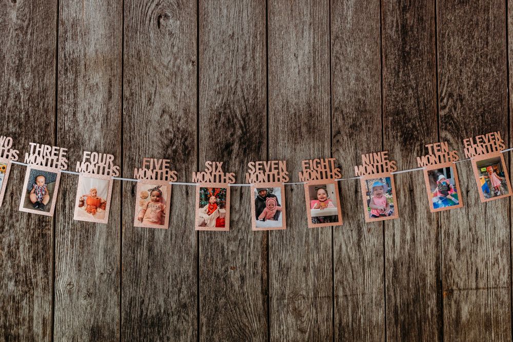 String of photo cards hung on twine against a weathered wooden wall.