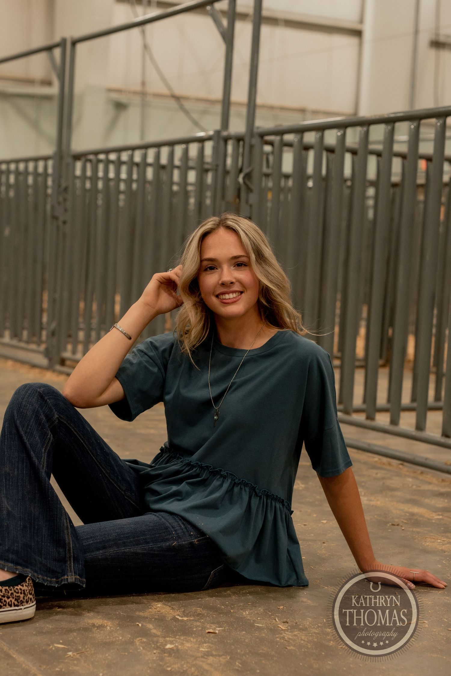 Relaxed fashion portrait on concrete floor with American flag in background.