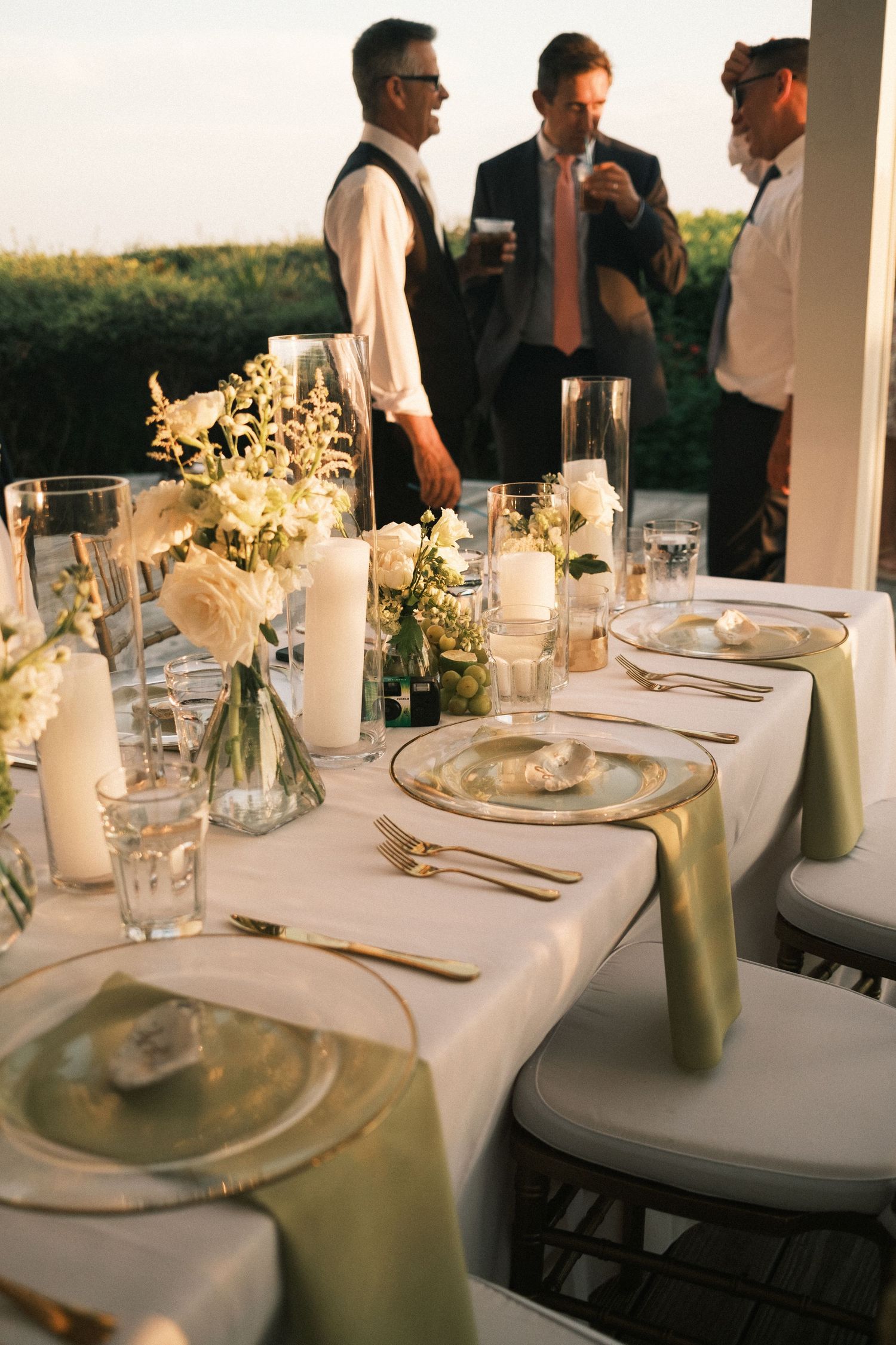 Elegant wedding reception table setting with white linens and floral centerpieces.