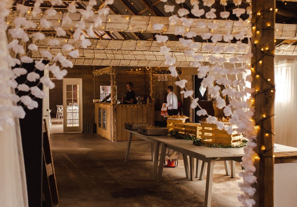 Wedding reception area decorated with hanging string lights and white paper lanterns.