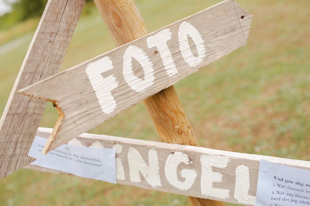 Wooden directional sign reading 'FOTO' mounted on rustic wooden posts.