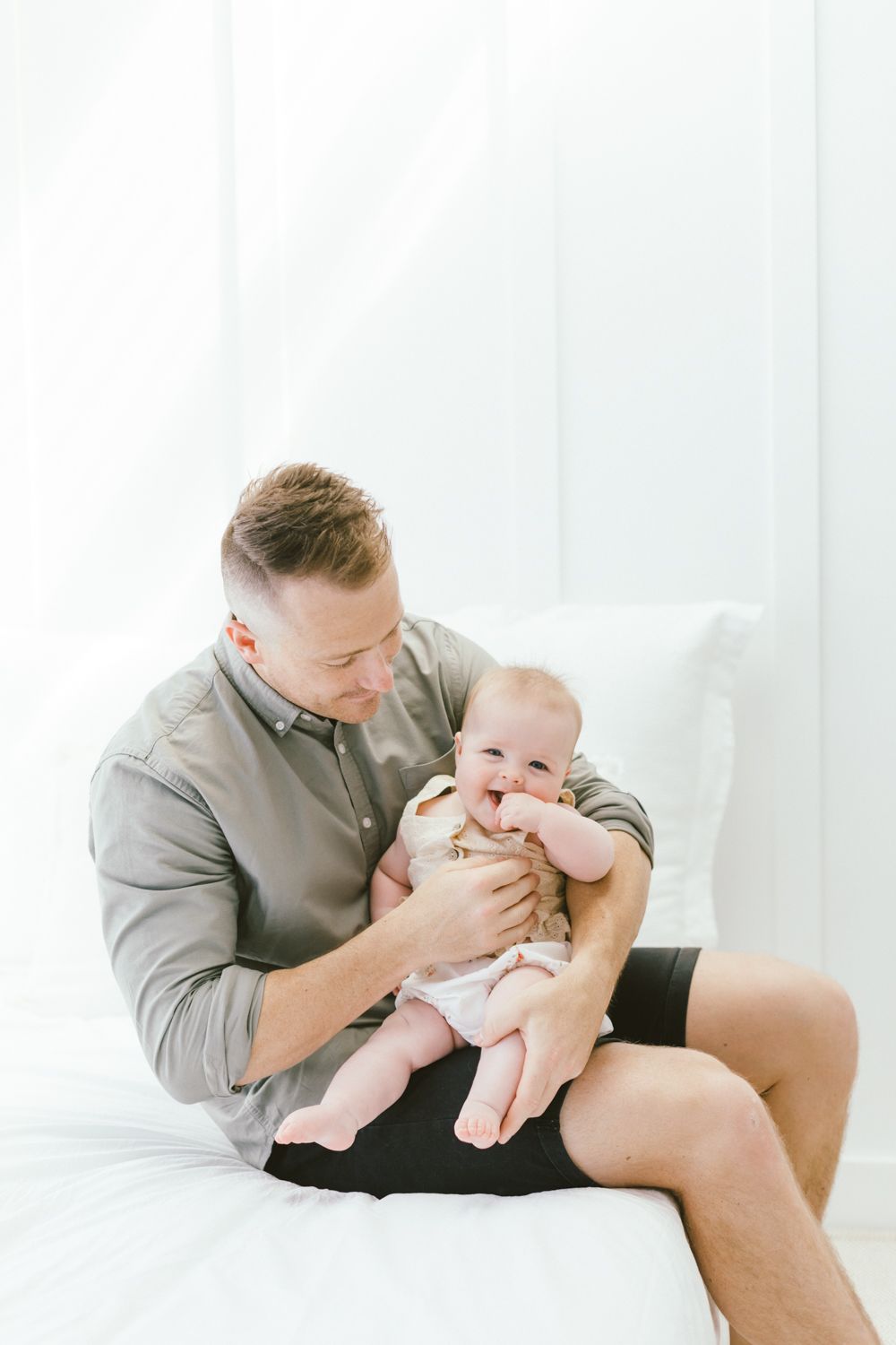 Playful interaction between parent and infant during casual lifestyle photoshoot.