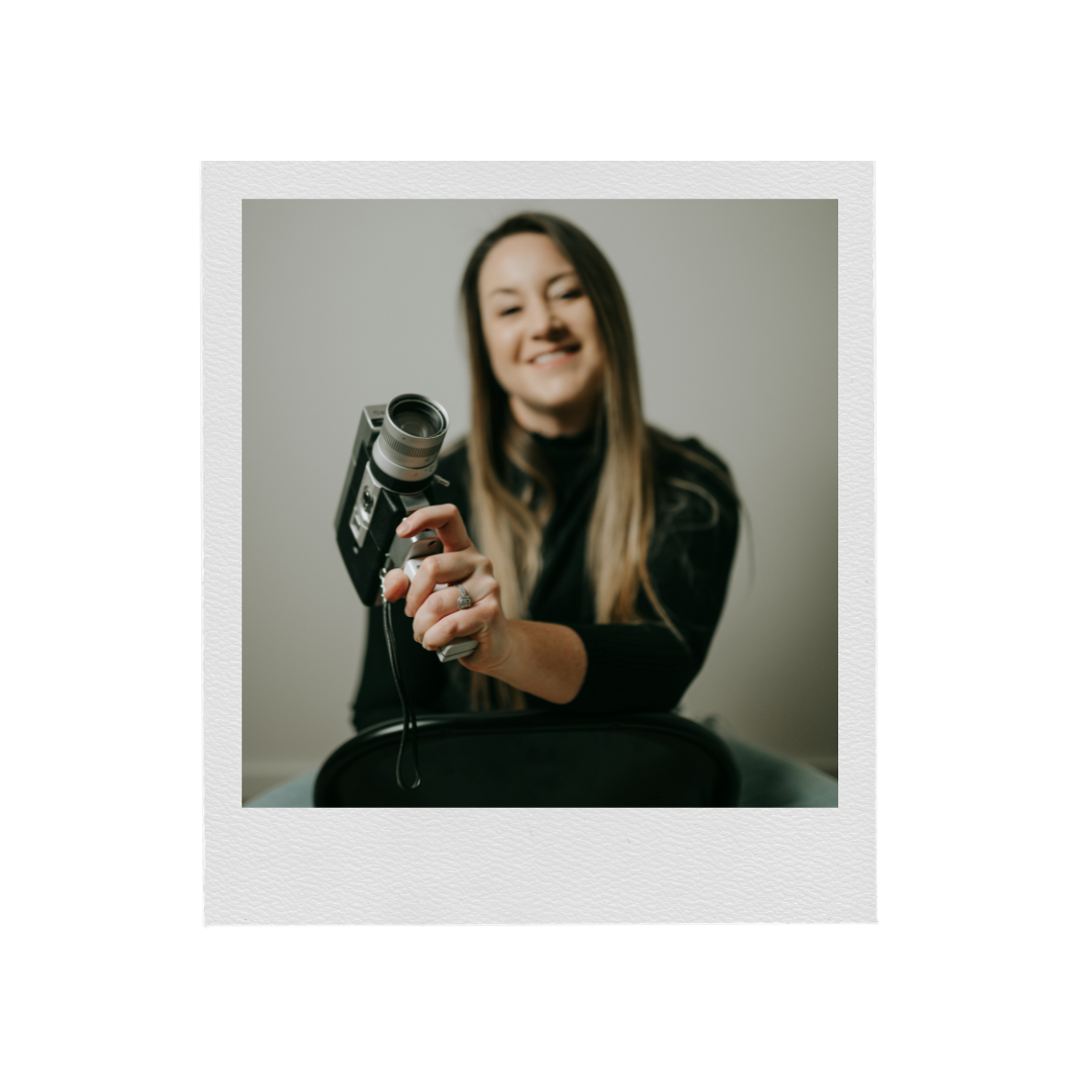 Artistic portrait photo of a photographer holding a vintage camera.