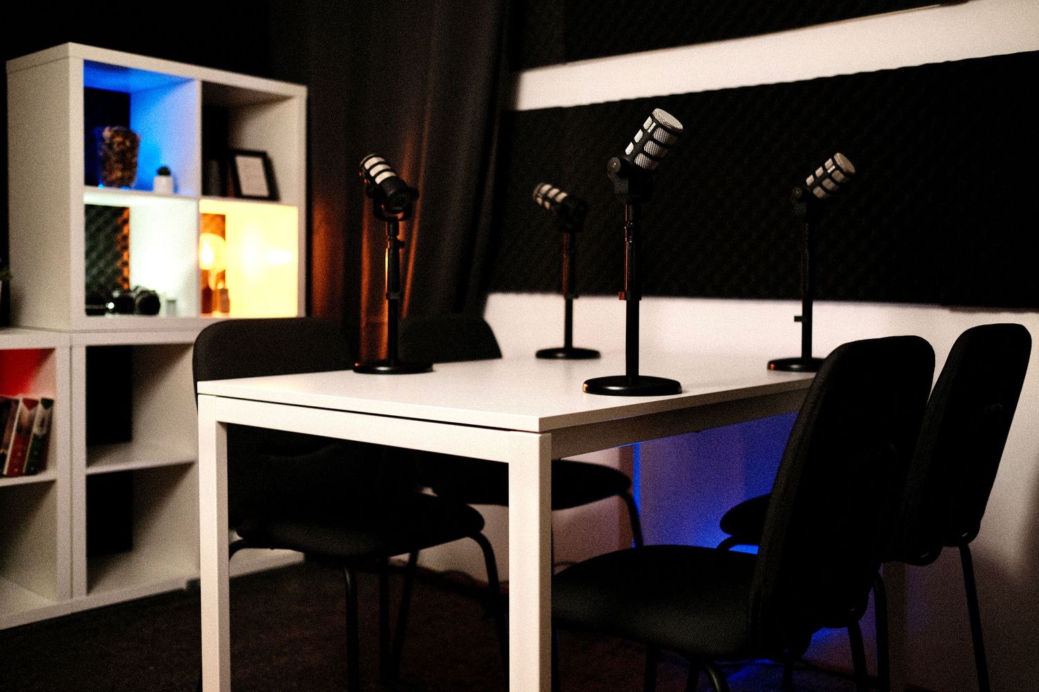 Dark studio setup with white furniture and blue ambient lighting visible in background.