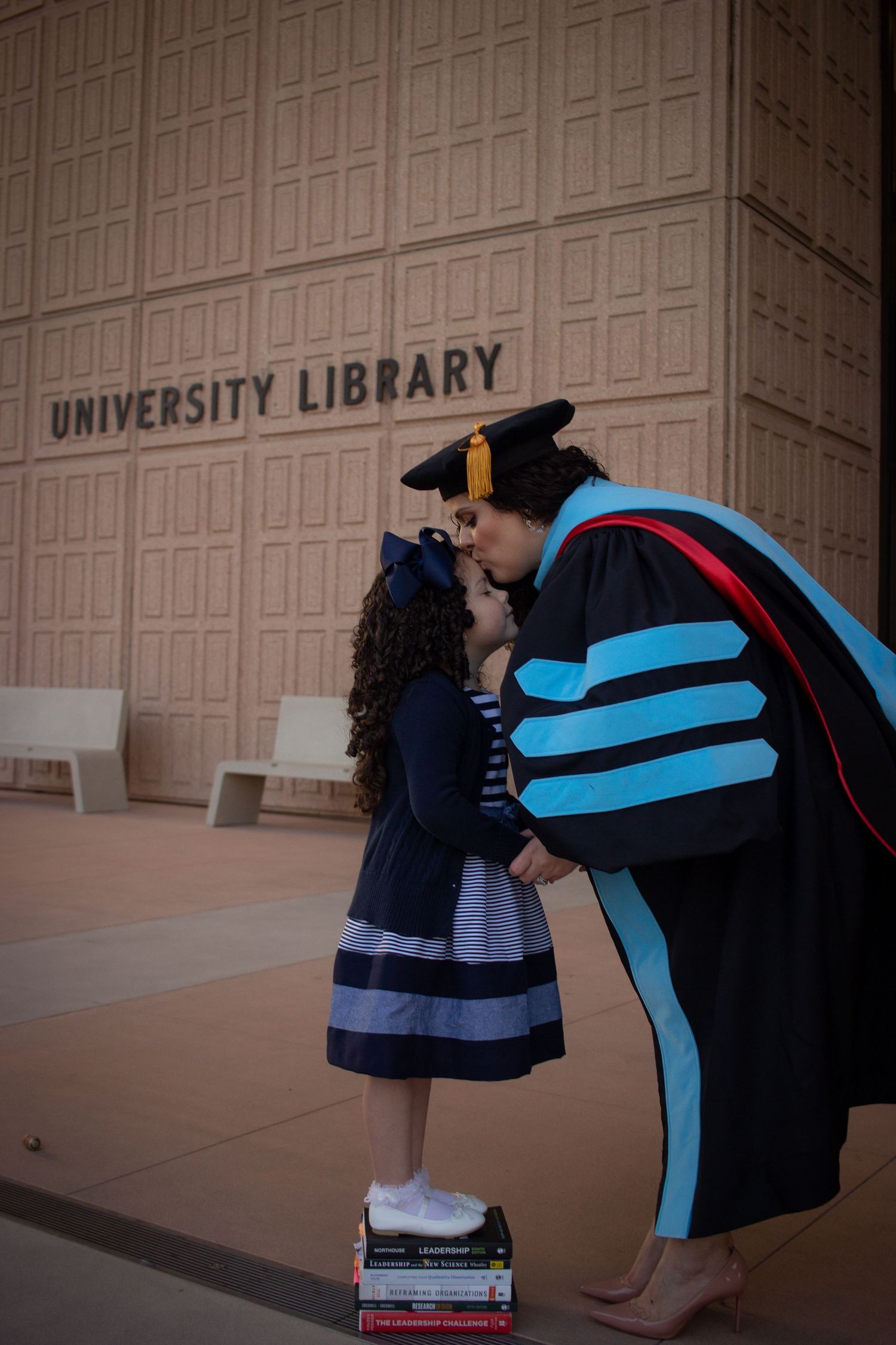 Graduation photoshoot shot at CSUN, California State University of Northridge. Female graduate photographed with daughter.
