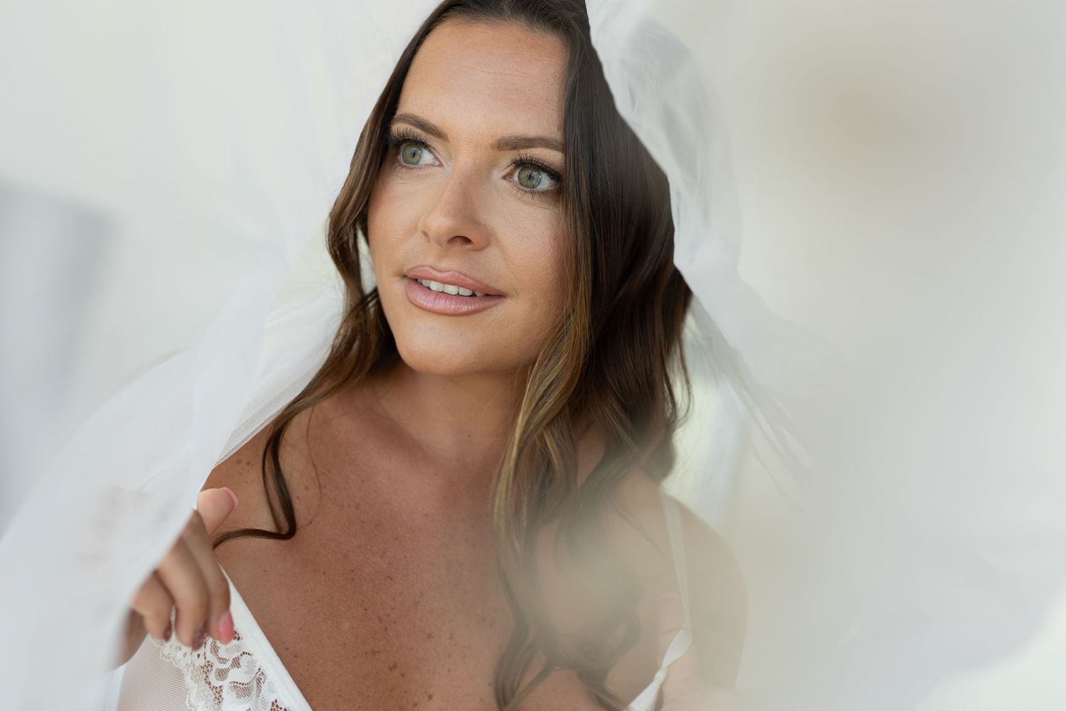 Portrait of a person wearing white lace in soft natural lighting.