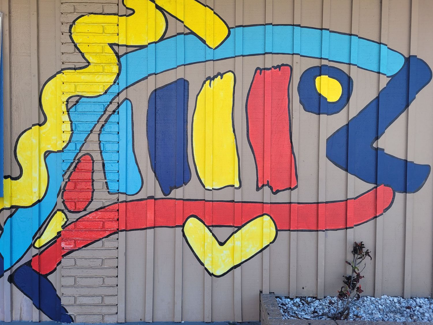 Brightly colored mural of a fish on a seafood restaurant casts the vision