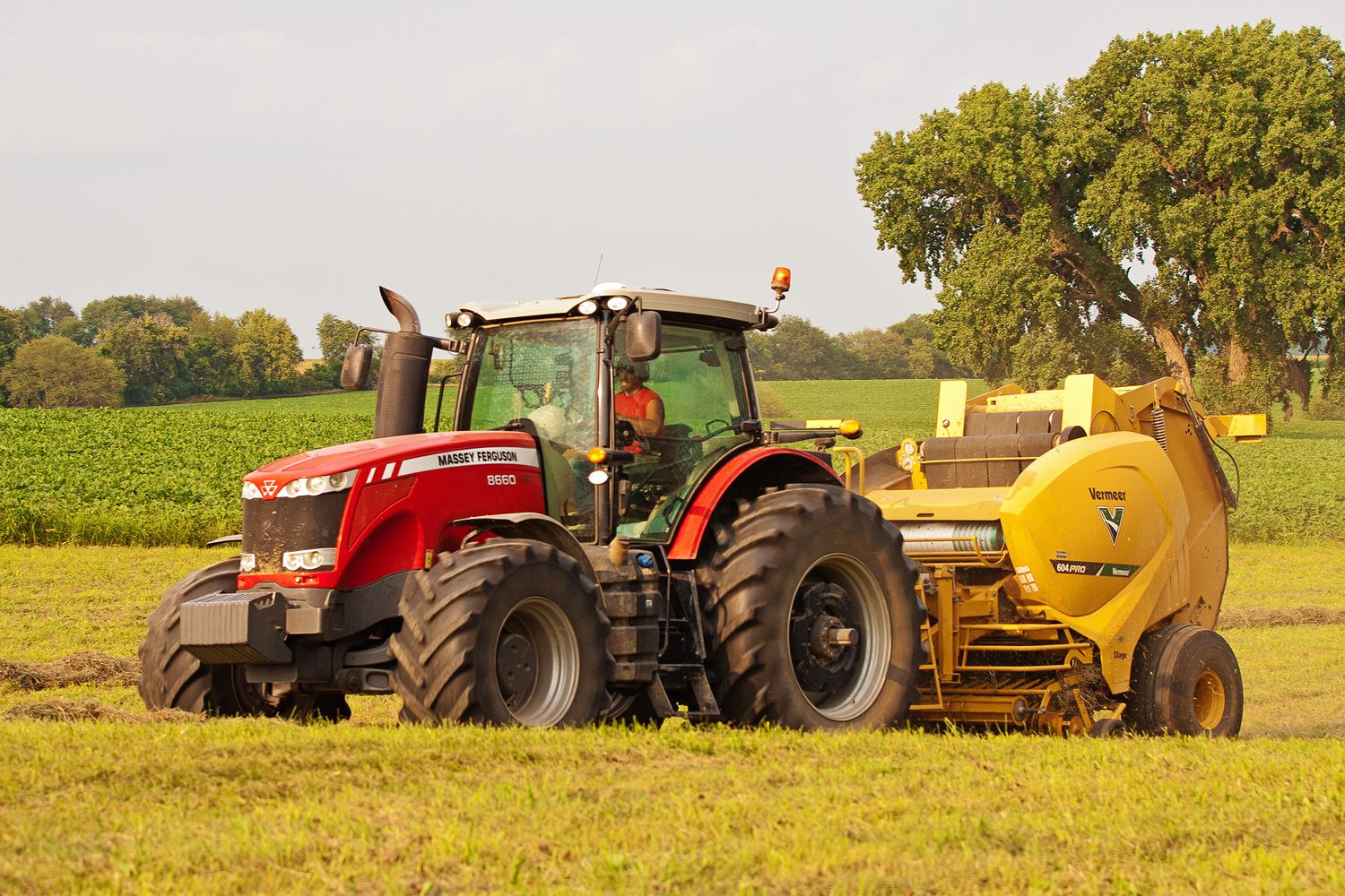 Massey Ferguson red tractor with Vermeer baler hay forage