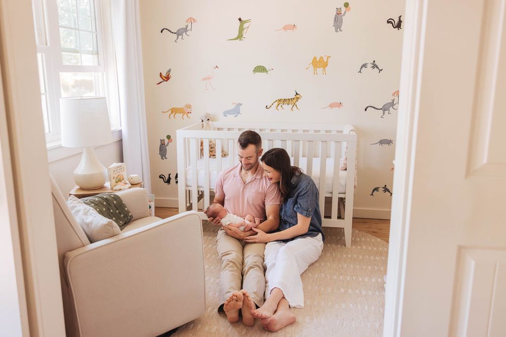 Children's bedroom with animal decals on walls features white furniture, minimal decor, and natural light.