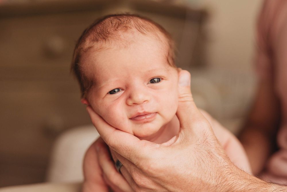 A series of eight close-up baby portraits showing different expressions and poses.