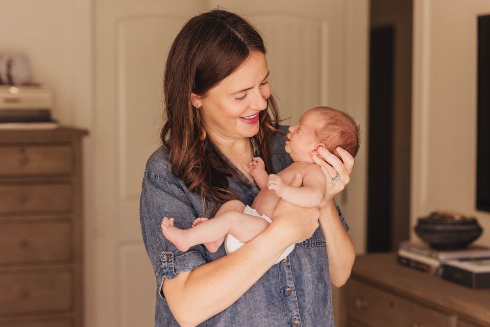 A tender parenting moment showing gentle affection between parent and baby in a warmly lit room.