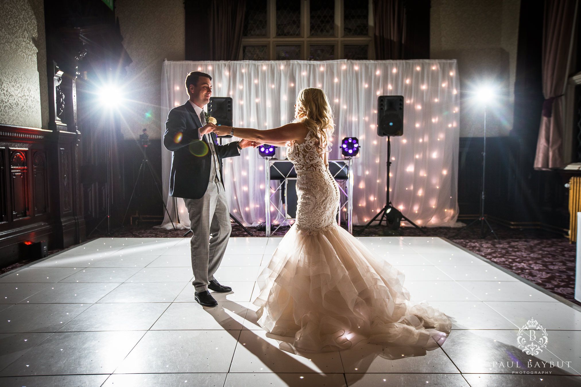 First dance moment captured with romantic lighting and a sparkly backdrop.