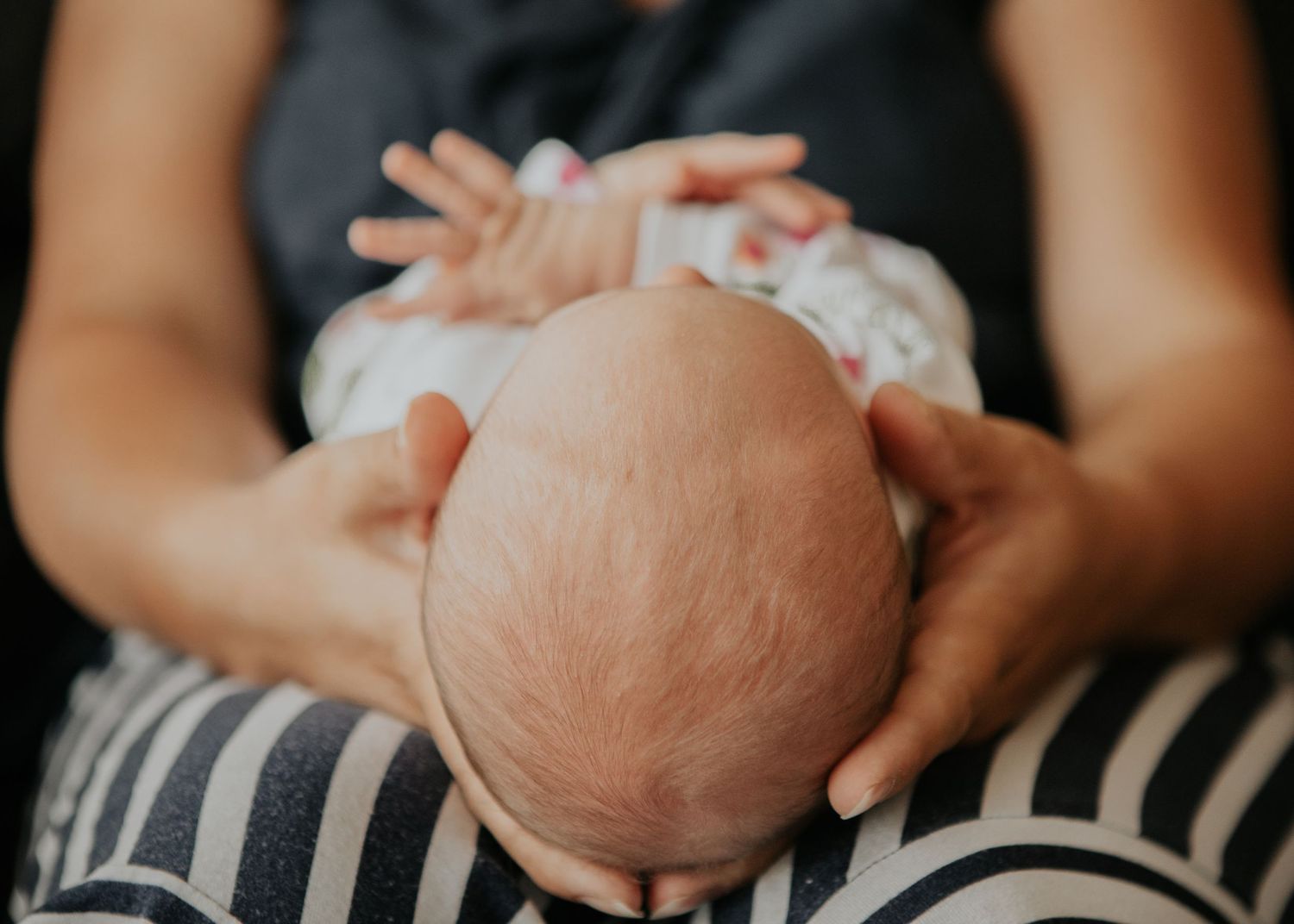 New born at home photo shoot with Cornwall new born photographer baby's head in mum's hands