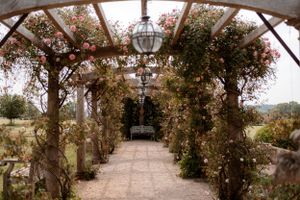 View of the rose lined pergola at Euridge Manor, luxury Cotswolds wedding venue