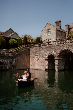 A couple share a quiet moment on the row boat on the lake at Euridge Manor, luxury Cotswolds wedding venue