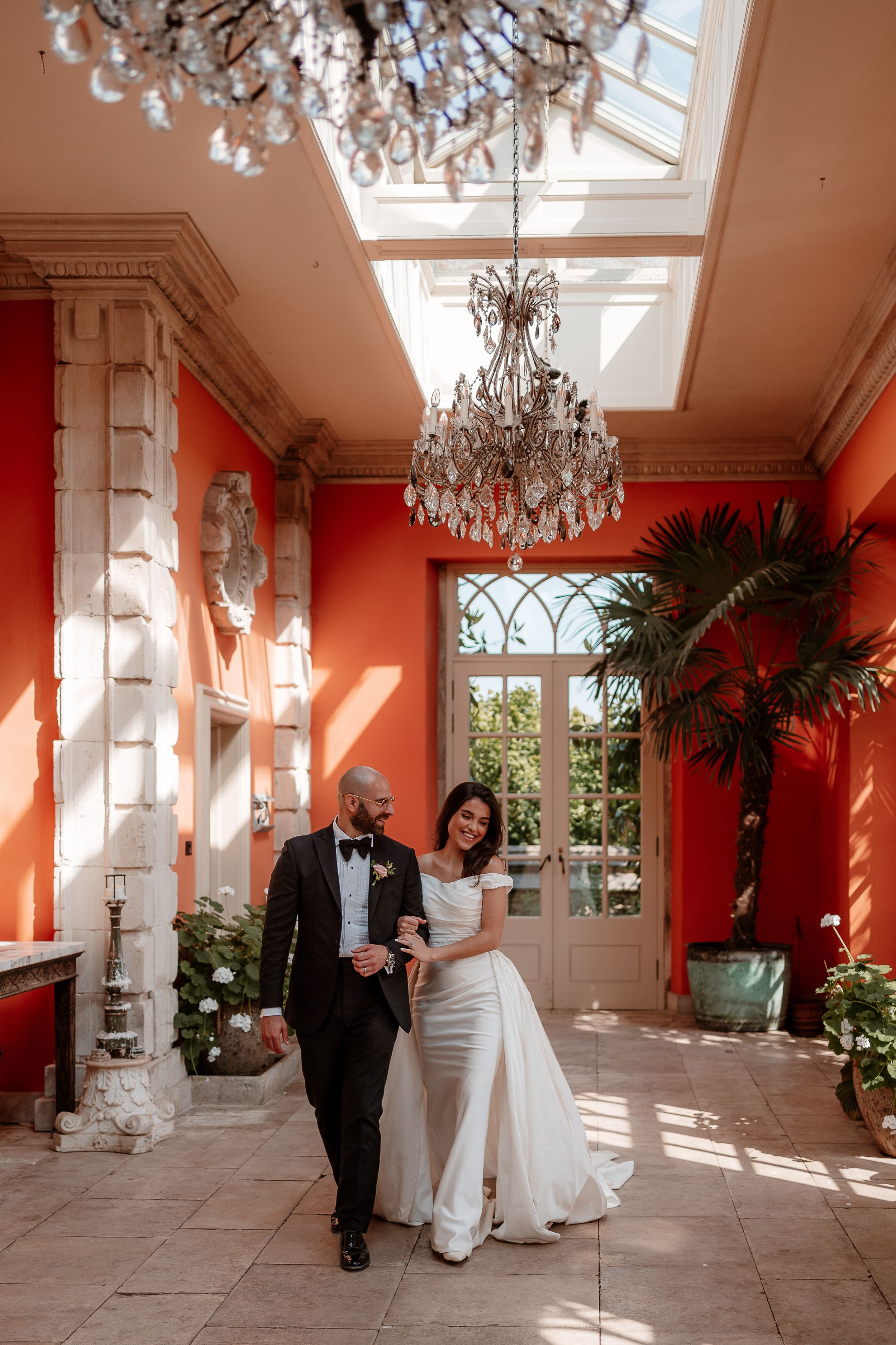 A couple walk arm in arm through the Organgery at Euridge Manor, luxury Cotswolds wedding venue after their wedding.