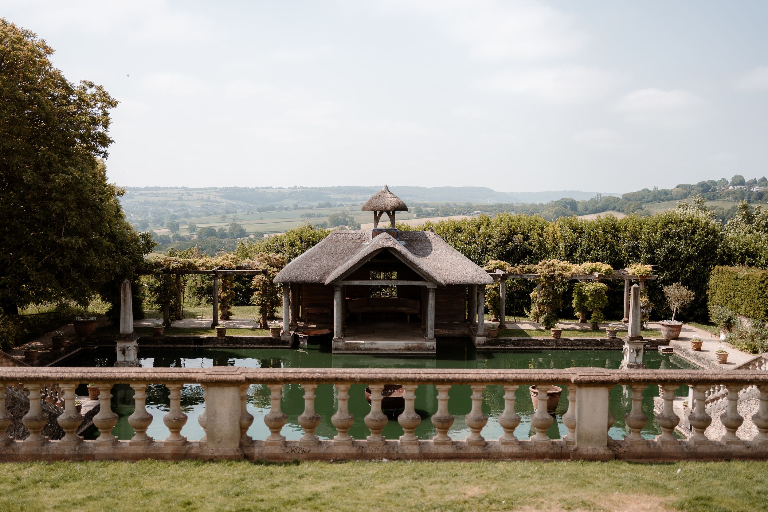 A view of the boathouse and lake from the Portico at Euridge Manor, luxury Cotswolds wedding venue