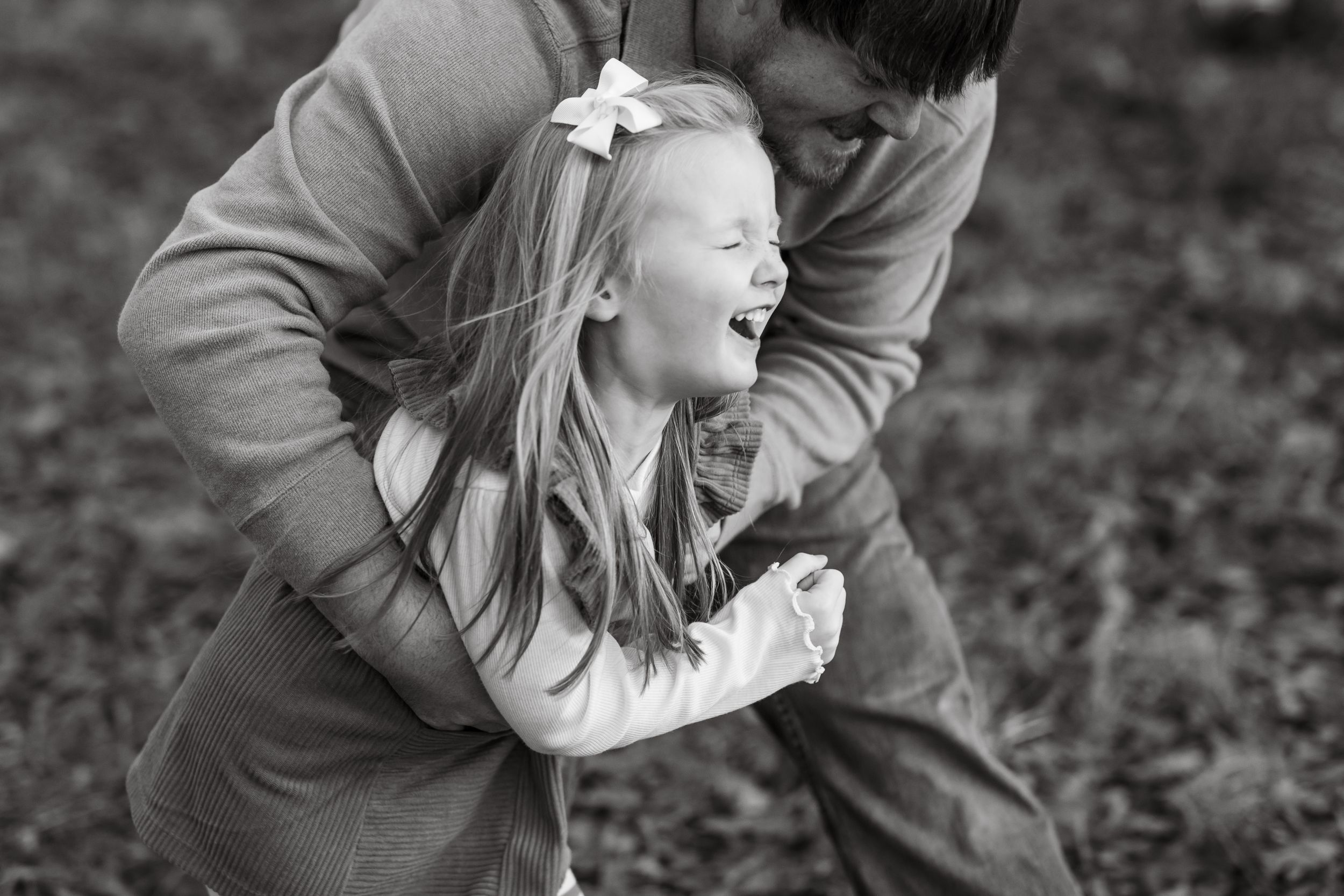 Black and white photo of playful family moments outdoors.