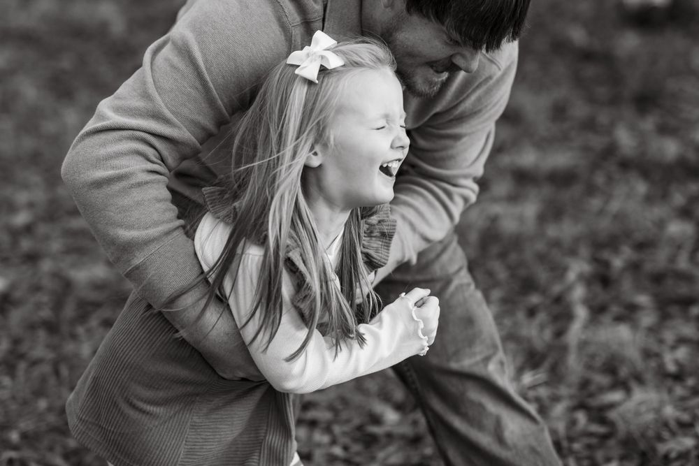 Black and white photo of playful family moments outdoors.
