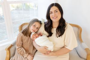 Family members gathered on couch sharing intimate moment with newborn.