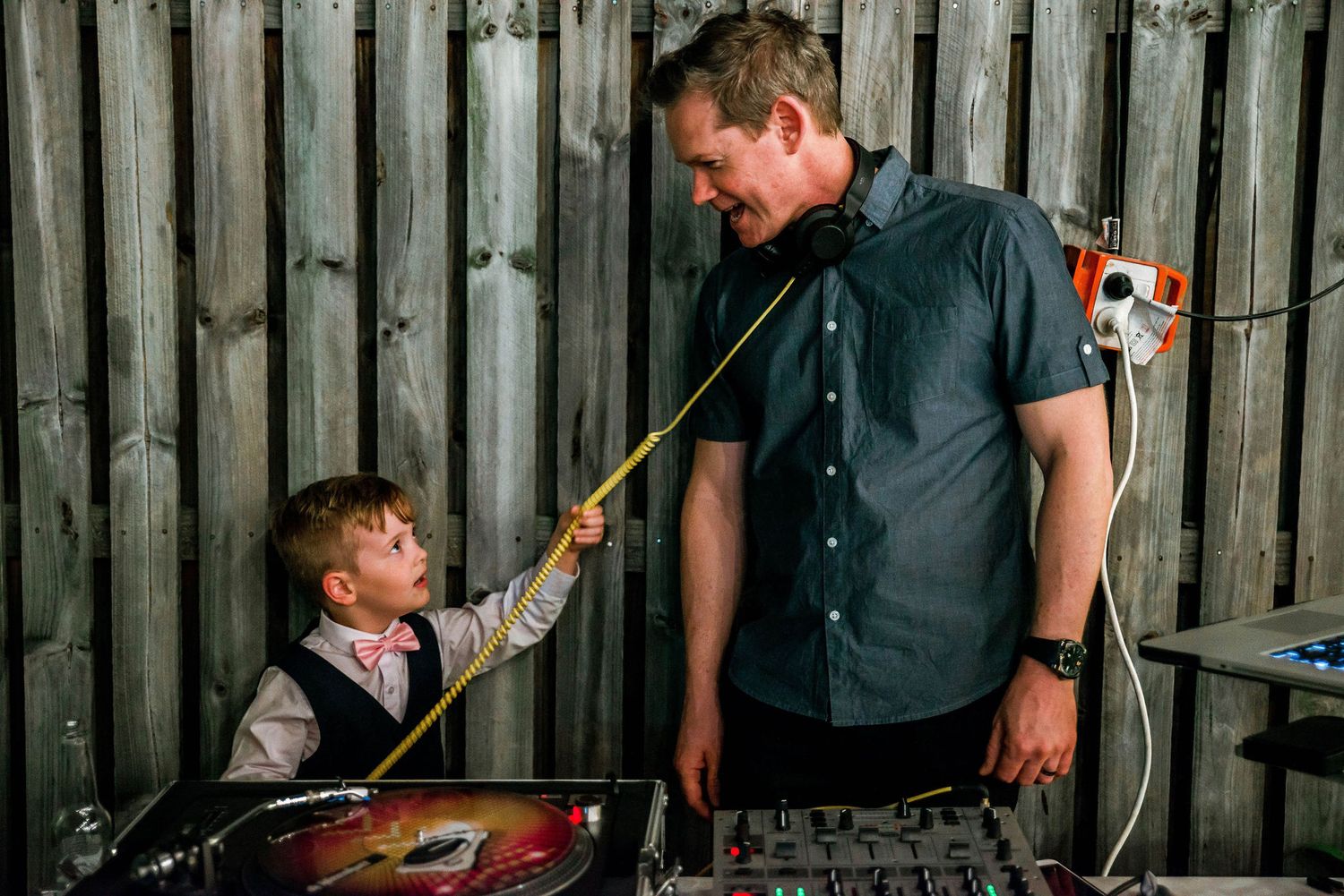 DJ setup at wedding reception with vintage wooden fence background.