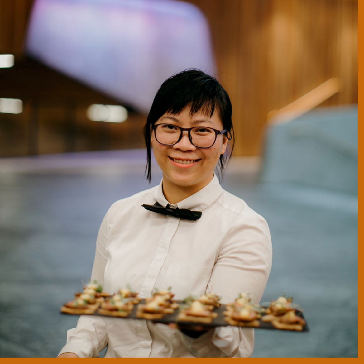 waitress in black bowtie serves canapes