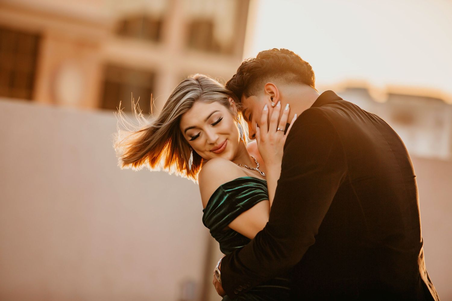 Romantic couple shares an intimate moment during golden hour sunset photography session.