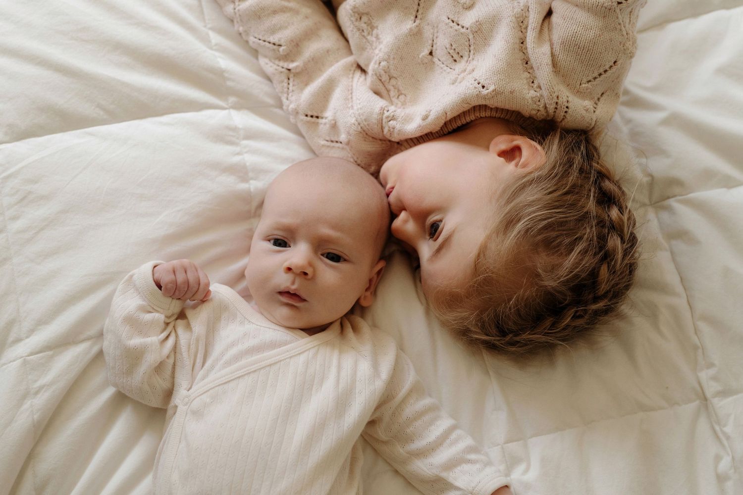 baby newborn lying on bed with sibling. Auckland in home photoshoot