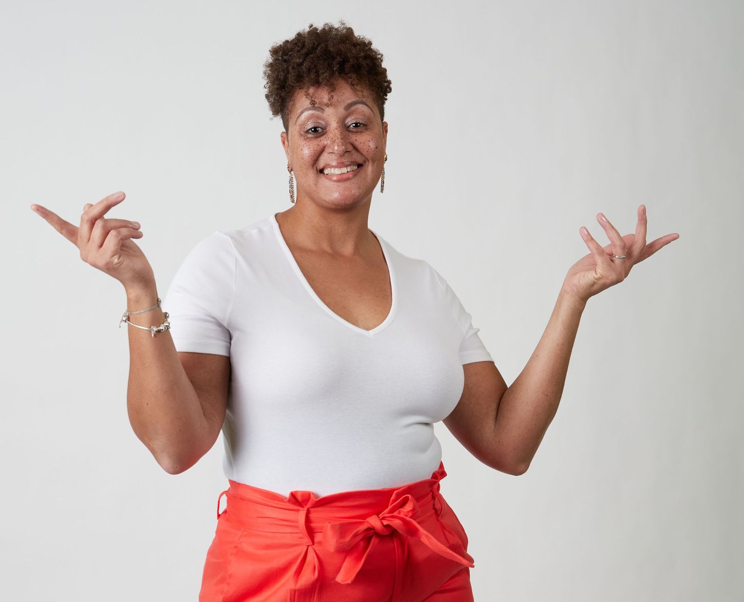 Expressive poses in white shirt against light background.
