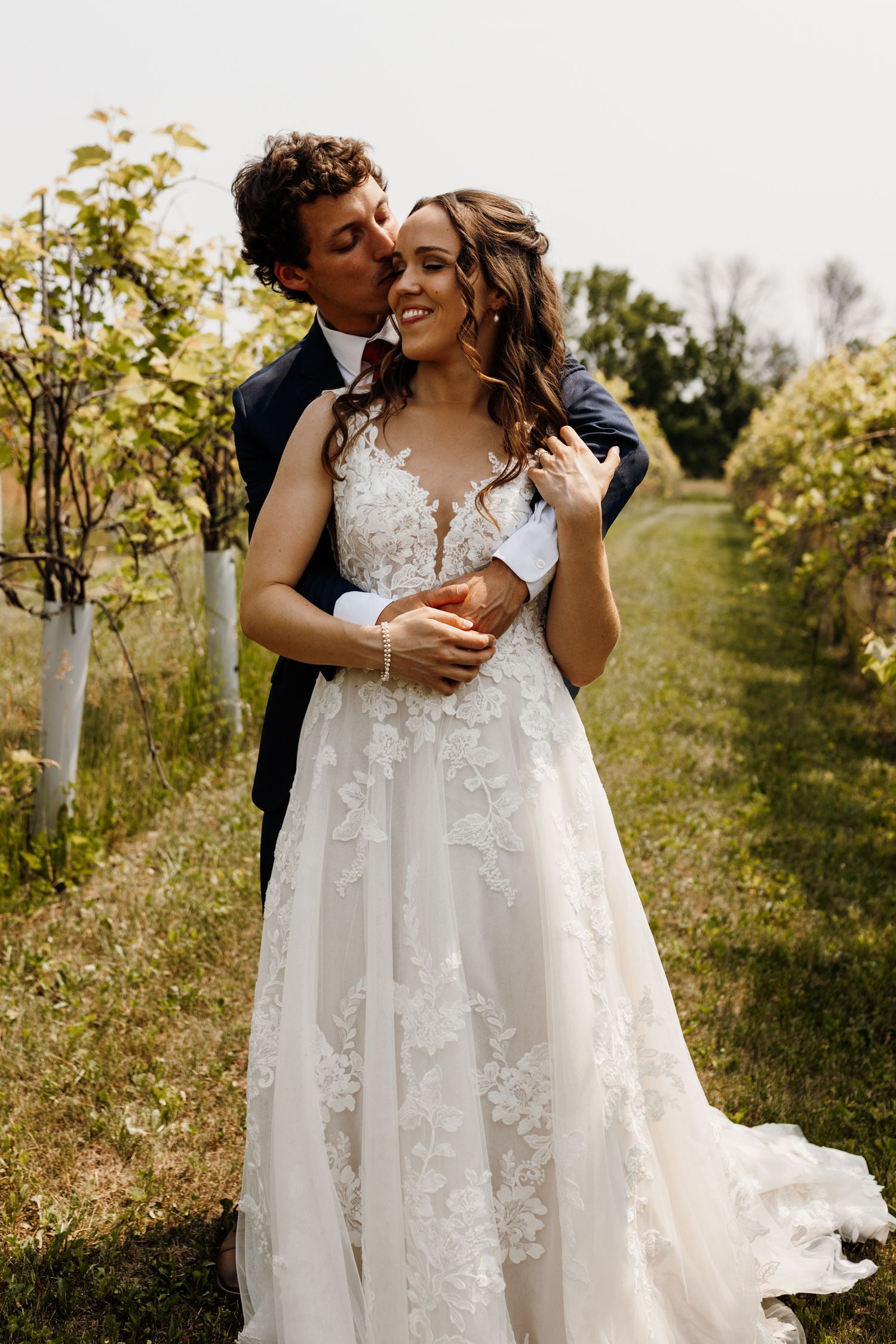 A romantic wedding photo of newlyweds embracing in a garden setting.