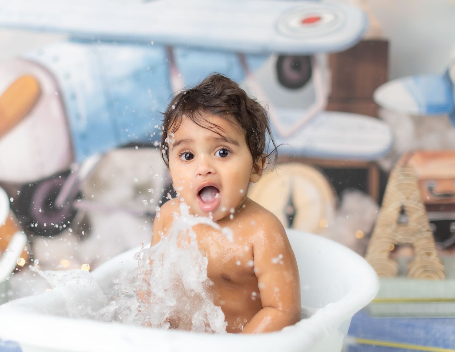 Playful bath photography session with splashing water and joyful expressions.
