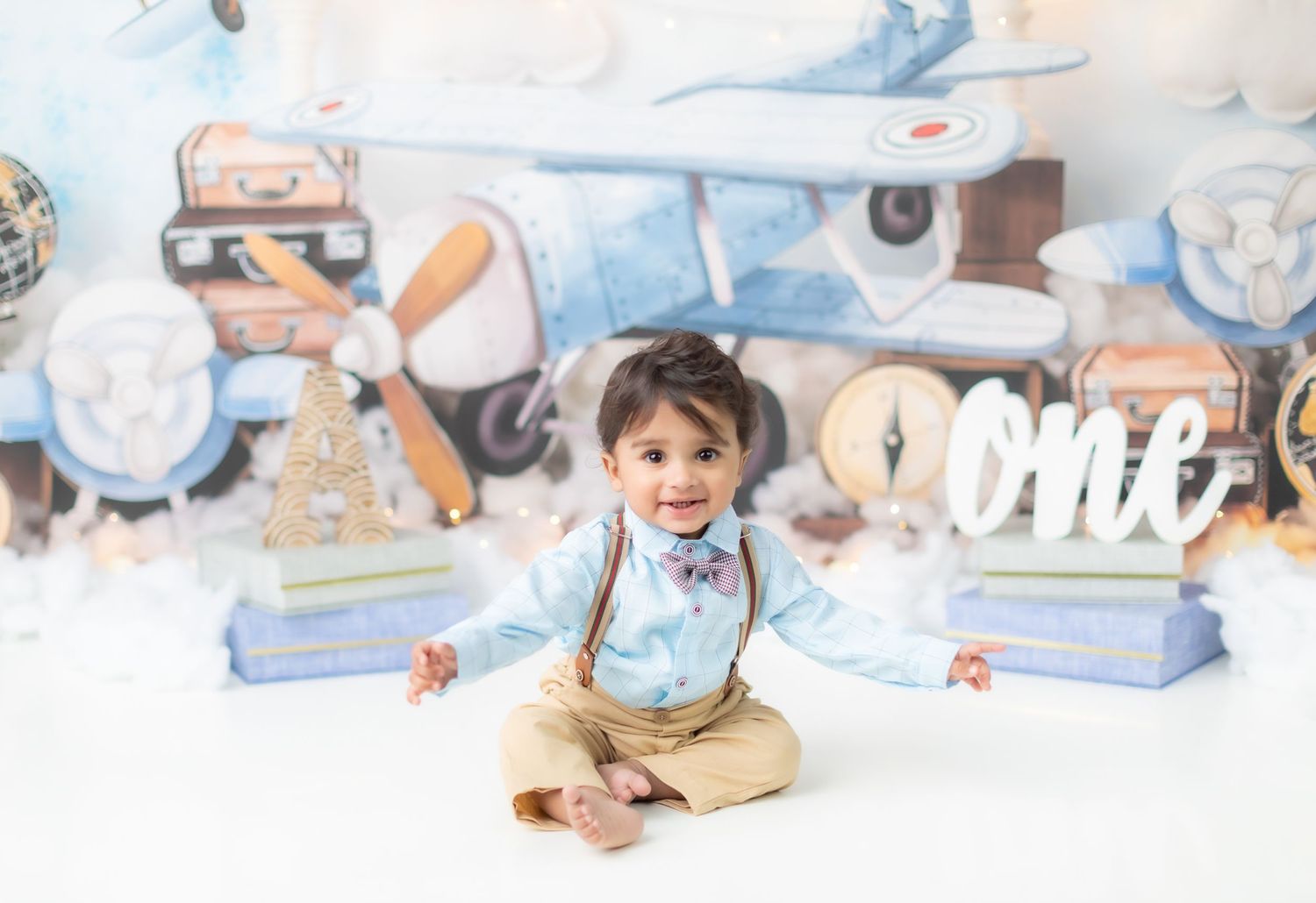 Baby enjoying a milk bath photo session with bubbles and white decor.