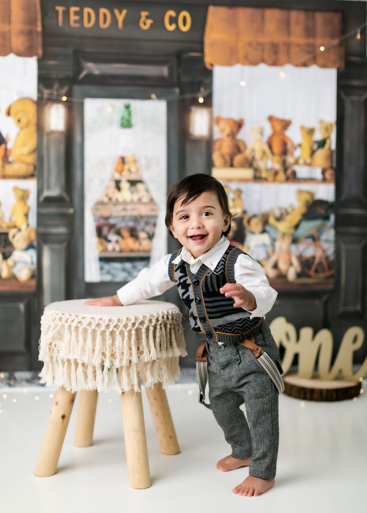 Vintage teddy bear shop setting with wooden stool and fringe details.