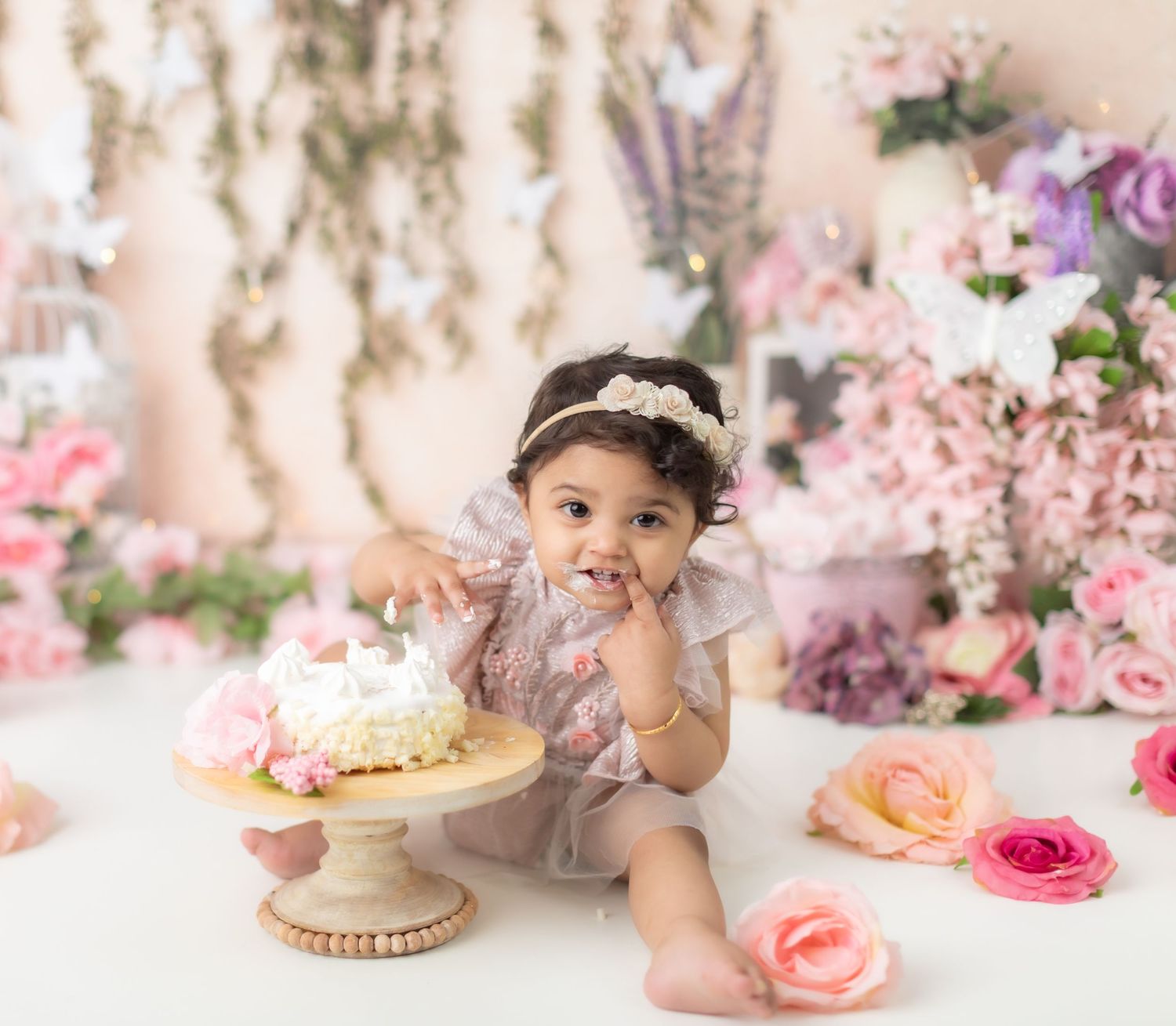 First birthday cake smash session with pink roses and elegant vintage styling.