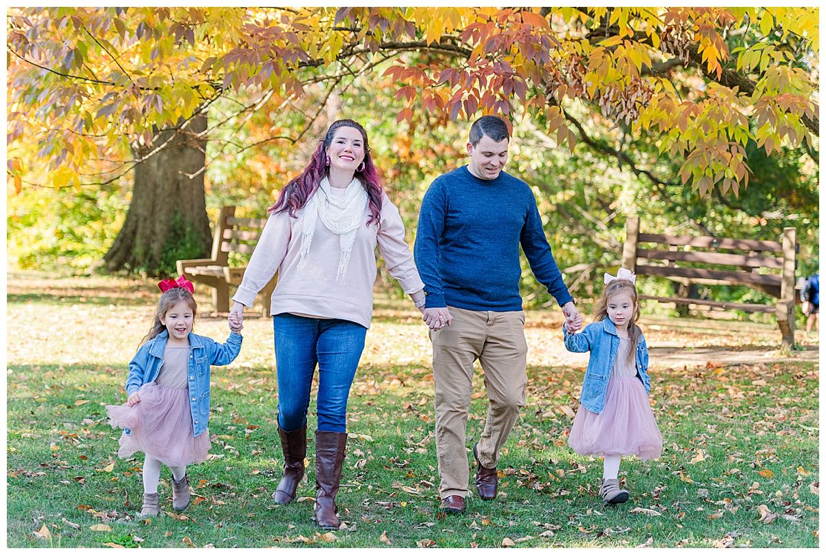 Family holding hands walking during photography session at Holliday Park Indianapolis Indiana