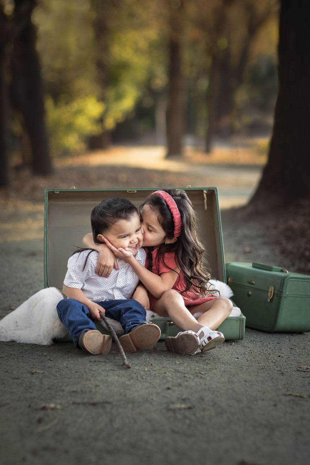 Series of photos showing two young people sitting by vintage suitcases in a park.