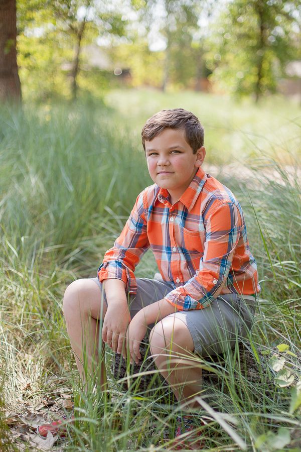 Portrait series showing someone in an orange plaid shirt sitting among tall grass.