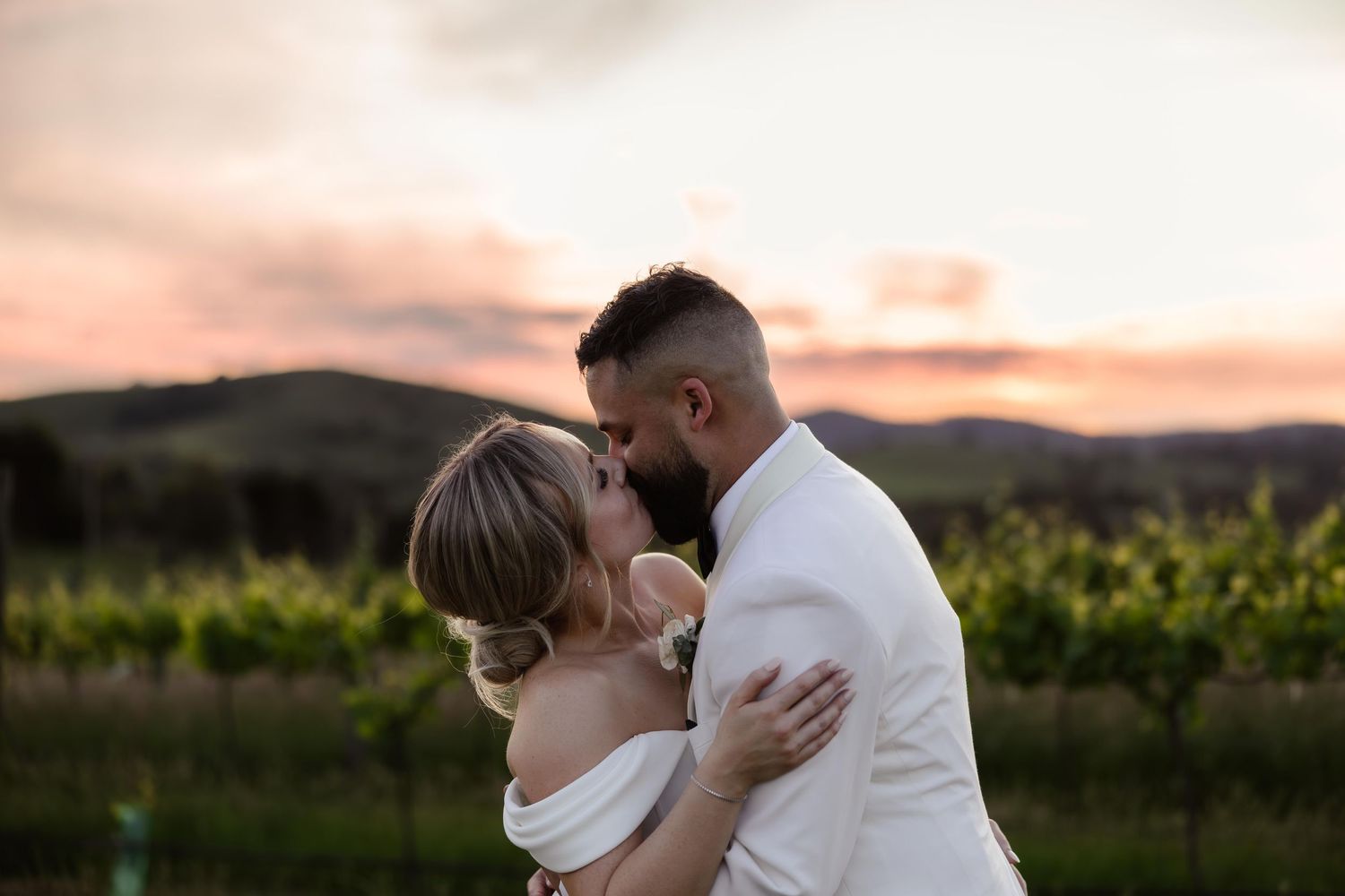 Romantic sunset wedding portraits in vineyard setting.
