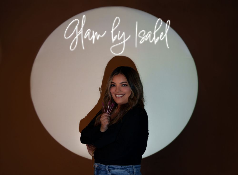 Silhouette against circular light with 'Glam by Isabel' text overlay.