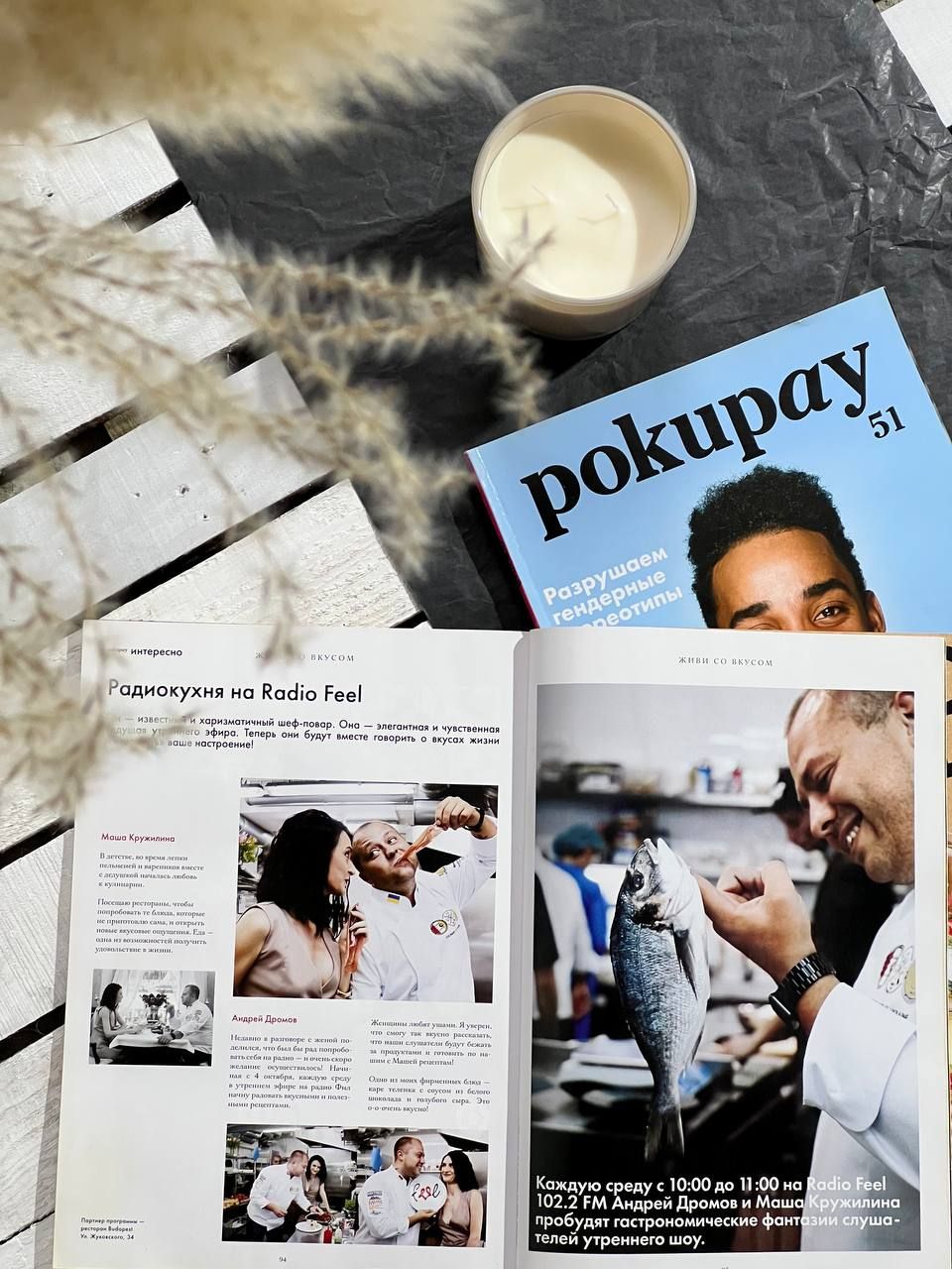 Lifestyle flatlay of Pokupay magazine spreads with milk glass and dried flowers.