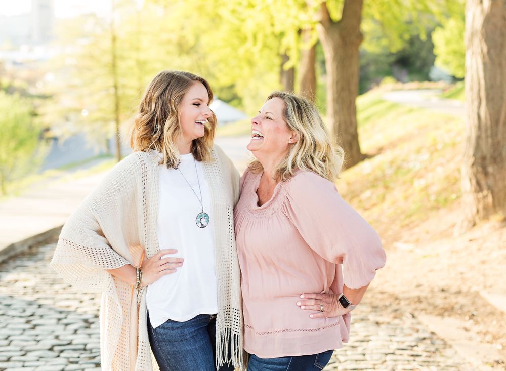 Two people sharing a laugh while standing together on a scenic path.