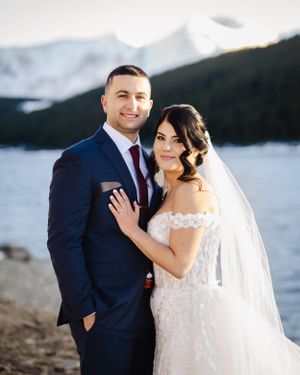 A wedding portrait with a scenic mountain lake backdrop.