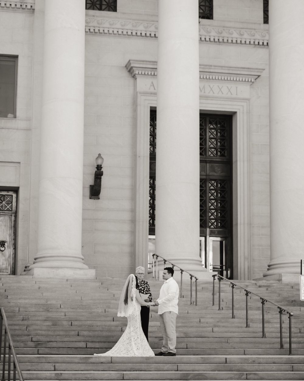 Wedding ceremony sequence on grand white stone steps of a neoclassical building with tall columns.